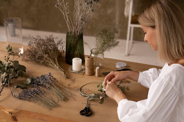 Mujer construyendo su propio arreglo de flores secas