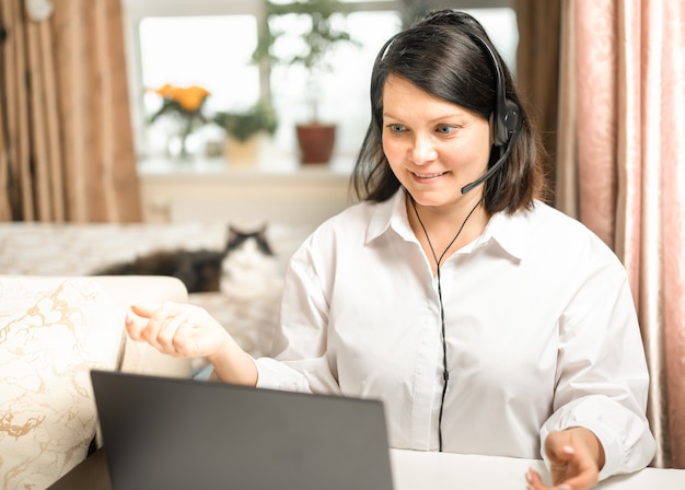 Mujer consulta por enlace de video con auriculares con laptop empresaria con videoconferencia