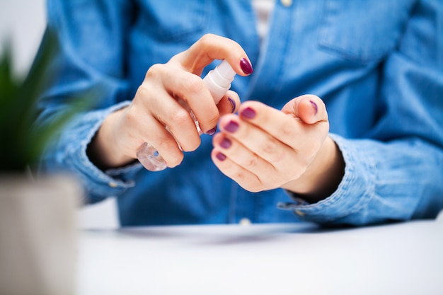 Foto mujer en el consultorio utiliza antiséptico para desinfección