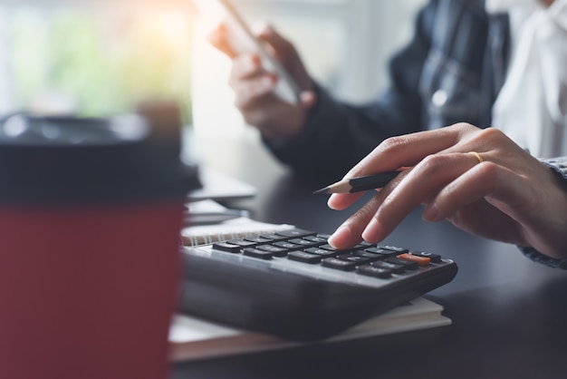 Mujer contable con calculadora durante el trabajo en la oficina