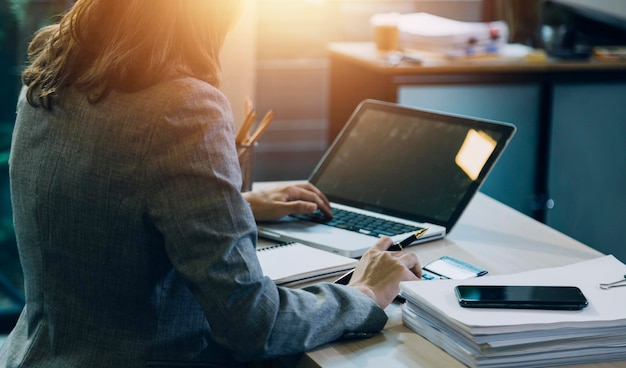 Mujer contable usa calculadora y computadora con bolígrafo