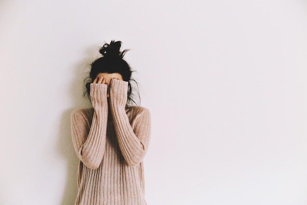 Foto mujer contra la pared