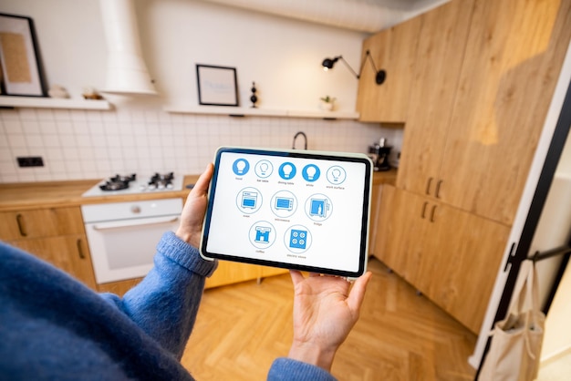 Mujer controla electrodomésticos de cocina con una tableta digital