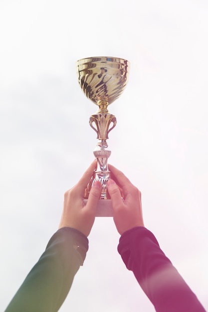 Foto mujer con copa trofeo de oro