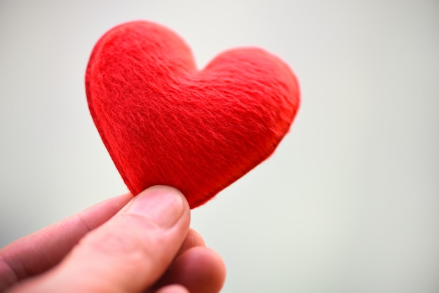 Mujer con corazón rosa en las manos para el día de San Valentín o donar ayuda para dar calidez amorosa cuidar - corazón en mano para el concepto de filantropía