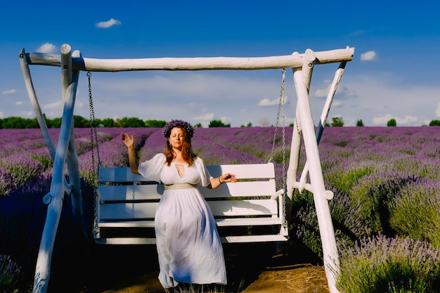 Mujer con corona de flores en campo de lavanda