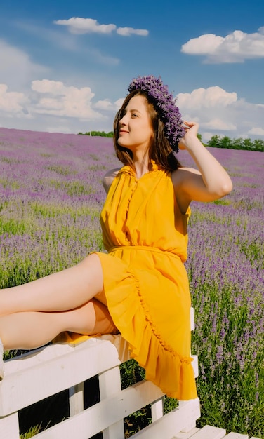 Mujer con corona de flores en campo de lavanda