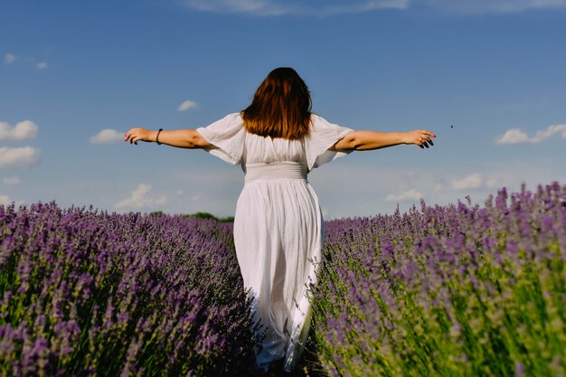 Mujer con corona de flores en campo de lavanda