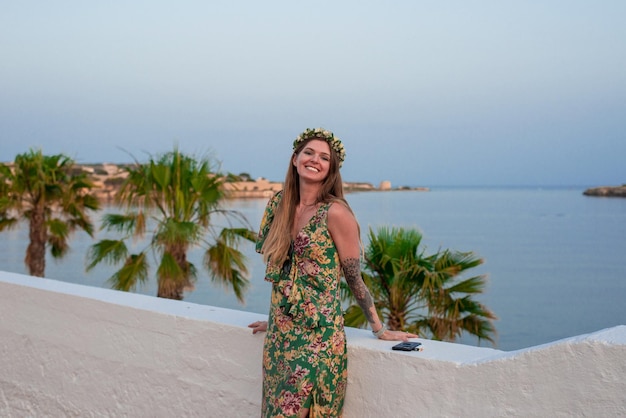 Foto mujer con corona nupcial de soltera junto al terraplén encalado parapeto del puerto mediterráneo