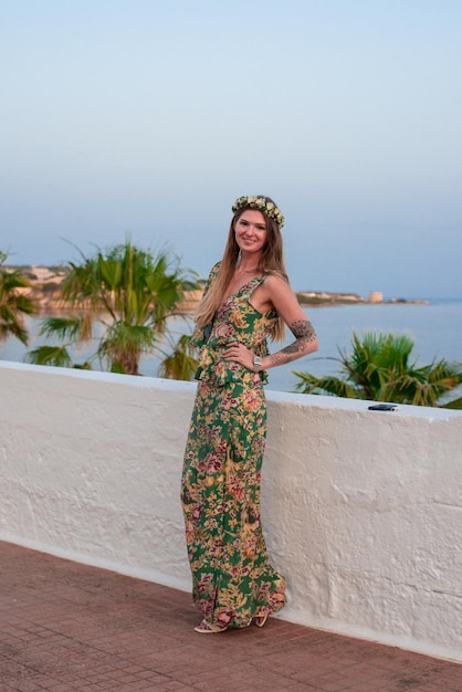 Foto mujer con corona nupcial de soltera junto al terraplén encalado parapeto del puerto mediterráneo