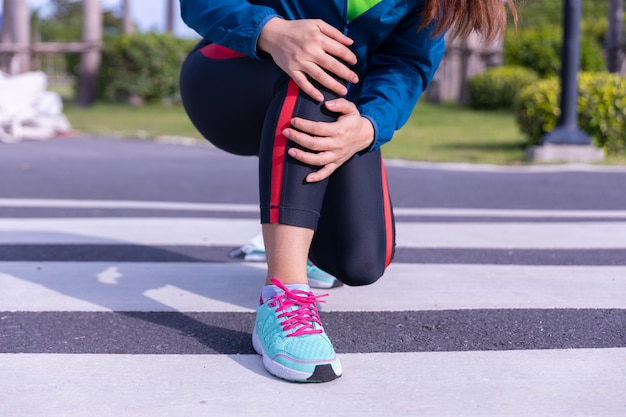 Mujer corredor atleta lesión de rodilla y dolor.