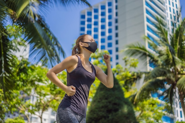 Mujer corredora con mascarilla médica corriendo en la ciudad en el contexto del coronavirus de la ciudad