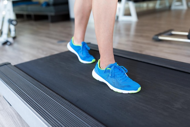 Mujer corriendo en la caminadora en el gimnasio