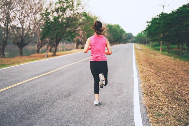 Foto mujer corriendo por la carretera