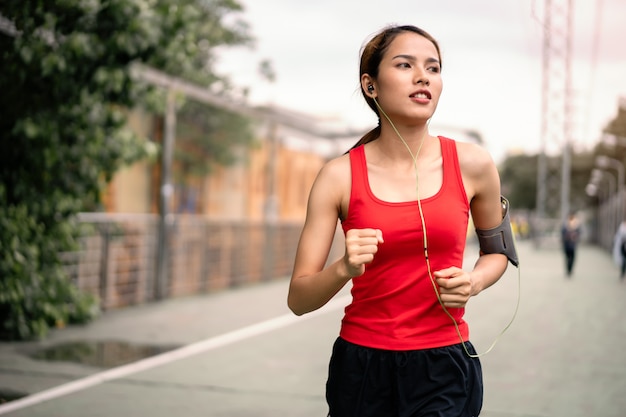 mujer corriendo en el carril de correr en la ciudad.