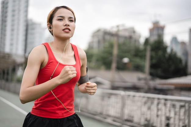 mujer corriendo en el carril de correr en la ciudad.