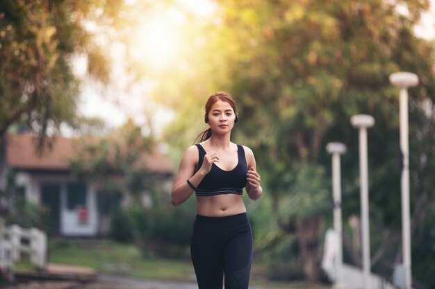 Mujer corriendo Corredor femenino que activa durante al aire libre en el camino