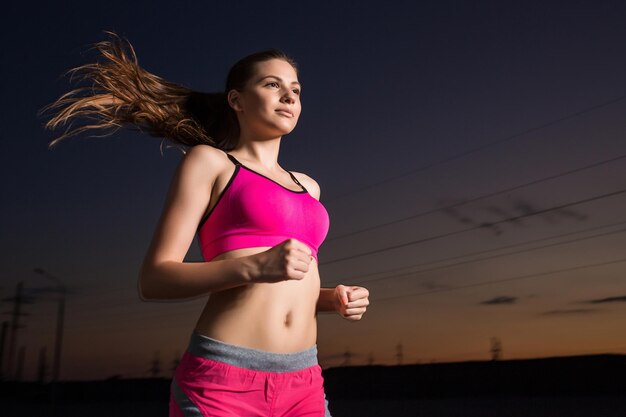 Mujer corriendo. Corredor trotando por la noche.