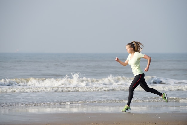 Mujer corriendo junto al mar