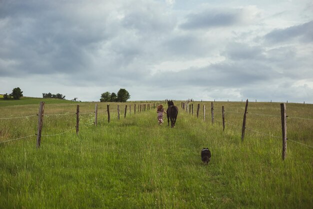 Mujer corriendo junto a la fotografía escénica del caballo