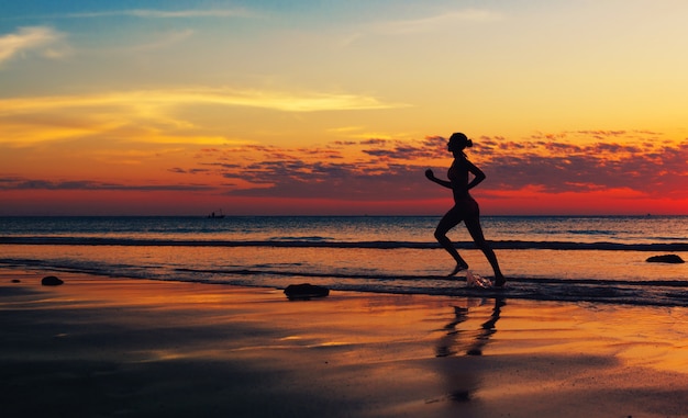 Mujer corriendo a lo largo de la costa del mar