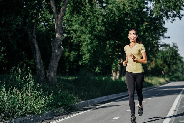 Mujer corriendo en pista durante la sesión de entrenamiento Corredora practicando en pista de carreras de atletismo