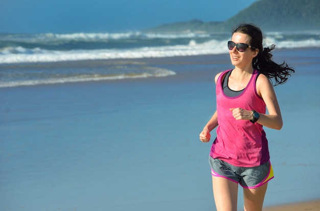 Mujer corriendo en la playa, hermosa chica corredor correr al aire libre, entrenamiento para maratón, ejercicio y concepto de fitness