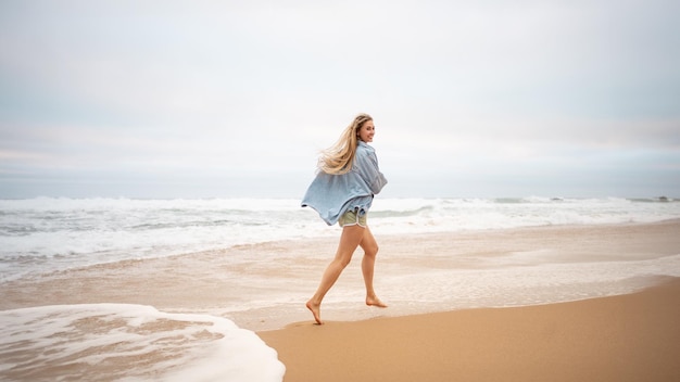 Mujer corriendo playa del océano y se da la vuelta