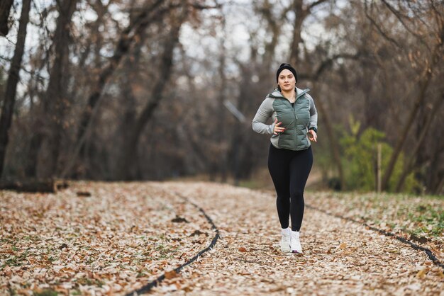 Foto mujer corriendo por un sendero en el bosque