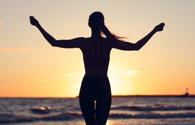 Mujer corriendo sola en el hermoso atardecer en la playa