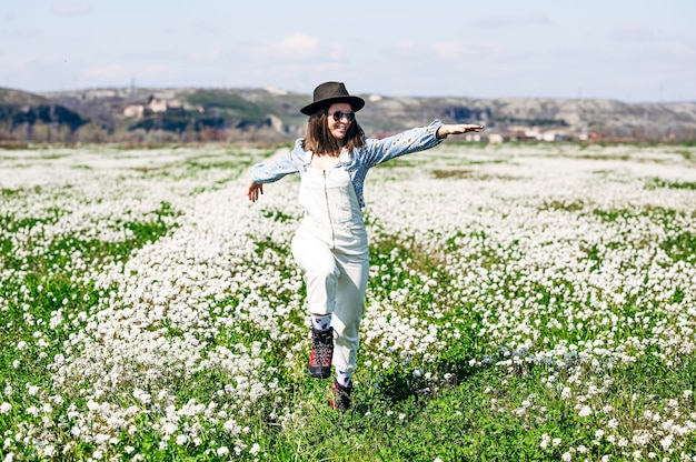 Foto mujer corriente feliz en campo de flores