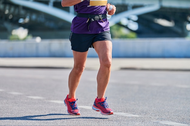 Mujer corriente. Mujer fitness para correr en ropa deportiva en la calle de la ciudad. Estilo de vida saludable, pasatiempo deportivo.