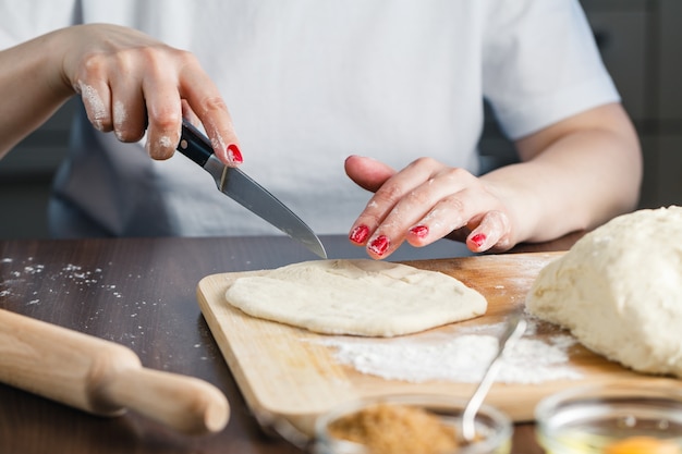 Mujer corta la masa para preparar galletas