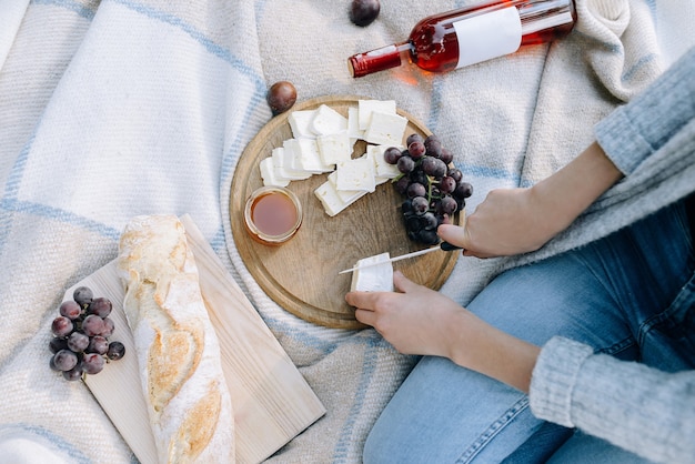 Mujer corta queso en una vista superior de picnic