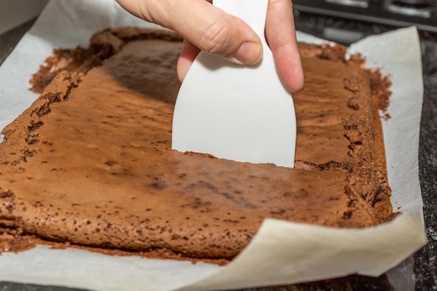 Mujer cortando brownie de chocolate gourmet casero