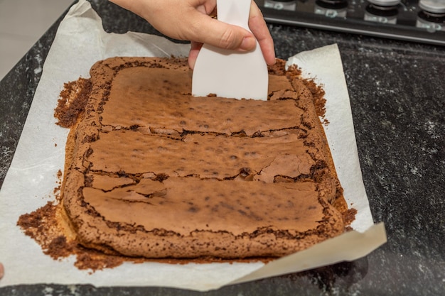 Mujer cortando brownie de chocolate gourmet casero