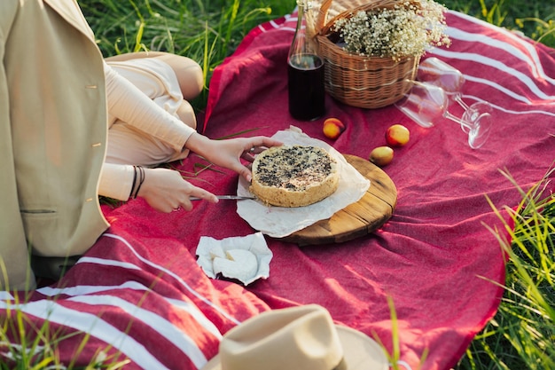 Mujer cortando pastel en un picnic