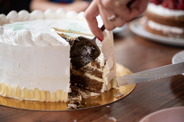 Mujer cortando y sirviendo un delicioso pastel de cumpleaños vegano