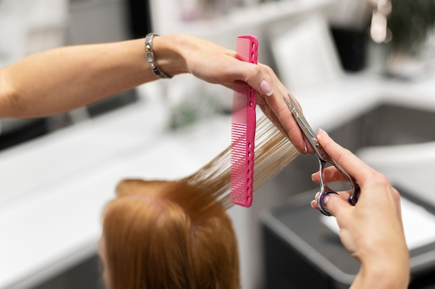 Foto mujer cortándose el pelo en el salón de belleza