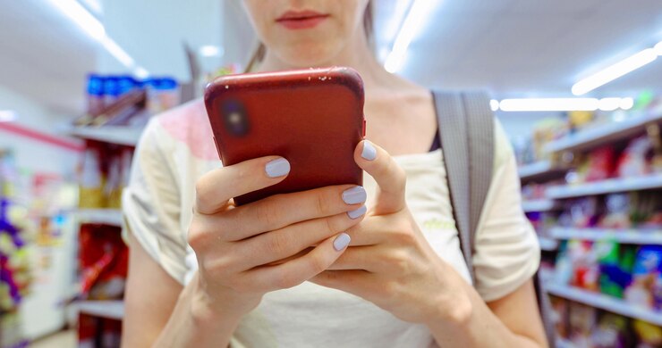 Foto mujer de la cosecha que usa el teléfono en la tienda