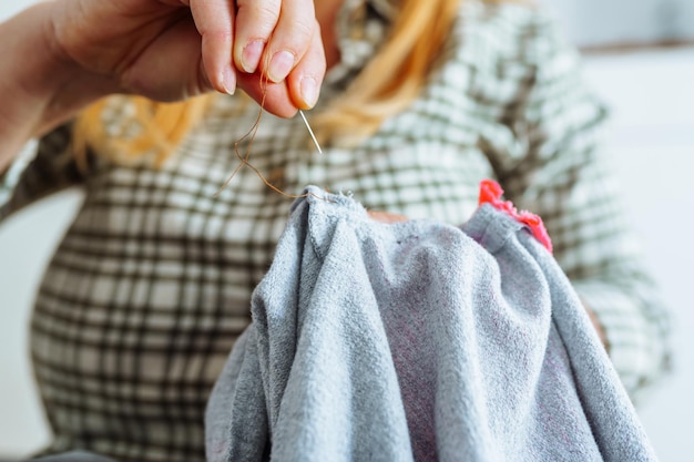 Foto mujer cosiendo agujero en ropa hecha a mano