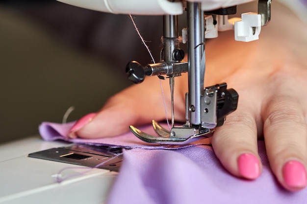 Mujer cosiendo un vestido en una máquina de coser