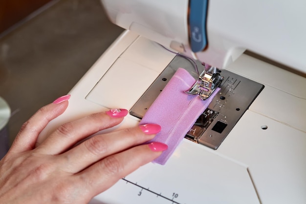 Mujer cosiendo un vestido en una máquina de coser