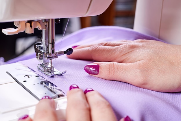Mujer cosiendo un vestido en una máquina de coser