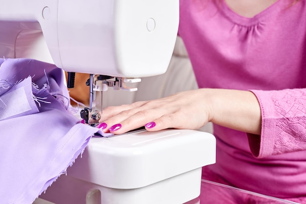 Mujer cosiendo un vestido en una máquina de coser