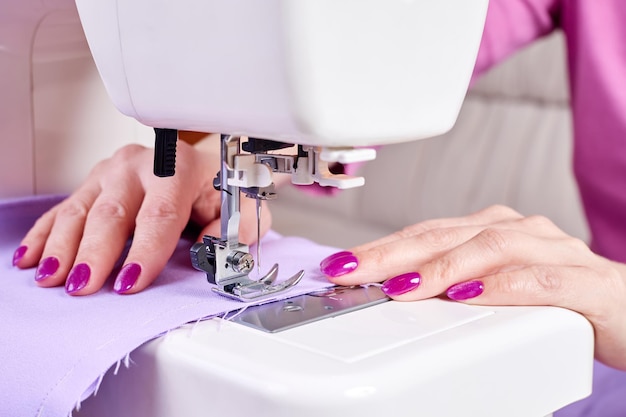 Mujer cosiendo un vestido en una máquina de coser