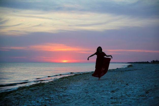 Mujer en la costa del mar al atardecer