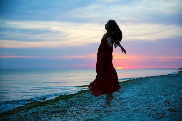 Mujer en la costa del mar al atardecer