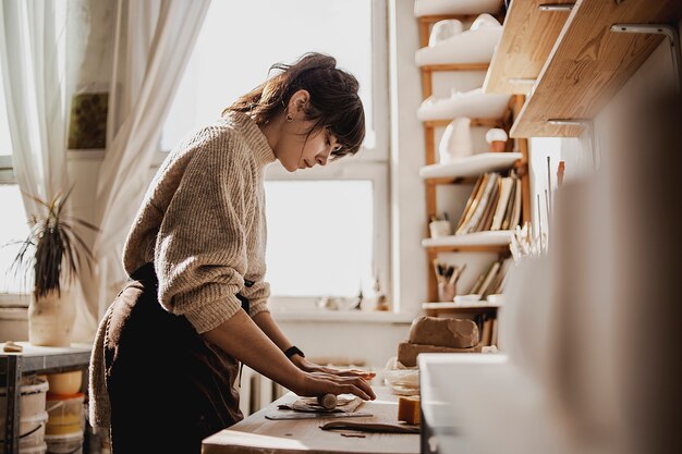 Mujer crea productos de cerámica hechos a mano en su estudio de trabajo.