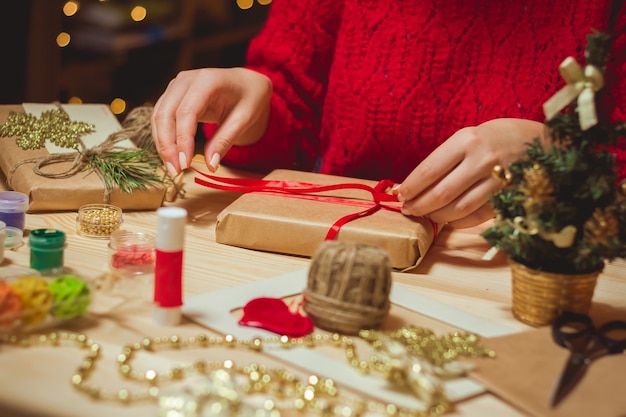 Mujer creando elegantes regalos de Navidad